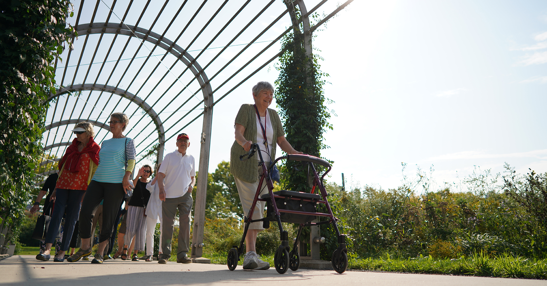 senior woman walking outside with a walker